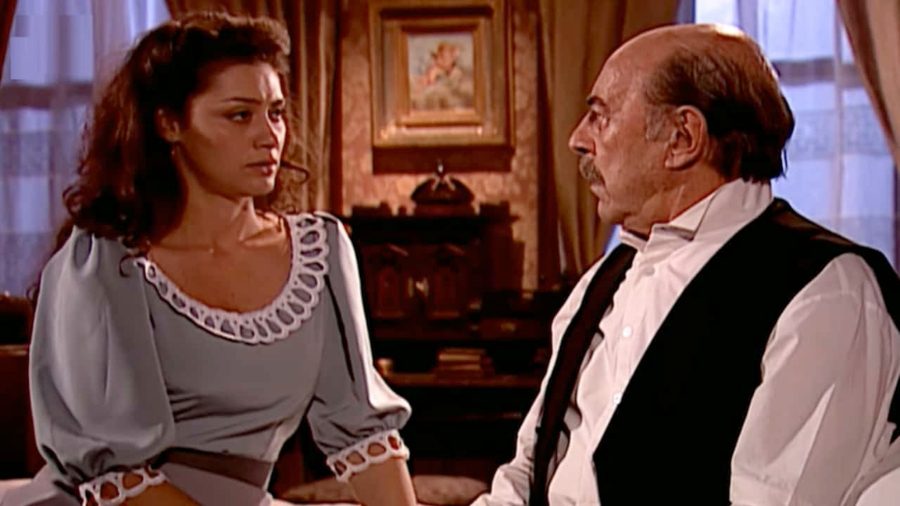 Paola conversa com Francesco sobre dinheiro e decisões financeiras em cena tensa, tentando impedir que ele entregue recursos a Anacleto na trama de época