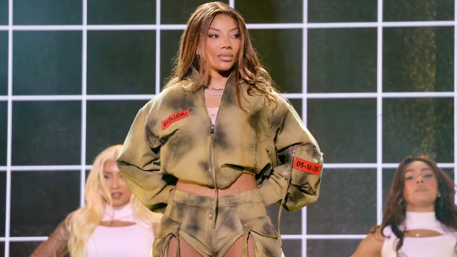 Ludmilla se apresentando no BBB com look estiloso, cantando em palco iluminado e clima de festa animada.